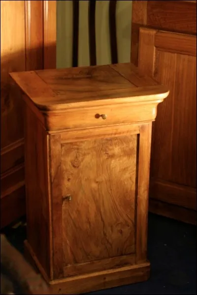 J'admire cette table de nuit ancienne, oubliée dans un coin, fabriquée dans un bois noble :