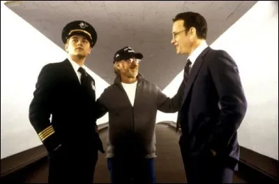On voit ici les deux h&eacute;ros du film encadrant leur r&eacute;alisateur, Steven Spielberg. Le film, qui raconte l'histoire vraie d'un escroc de g&eacute;nie &acirc;g&eacute; d'&agrave; peine 16 ans, c'est...&nbsp;?