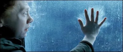Que se passe-t-il avec la main de Ron Weasley, posée sur la vitre d'un compartiment de train ?