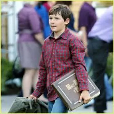 Ce jeune garçon tient ici le livre sans lequel il ne pourrait comprendre la ville de Storybrooke. Il se prénomme Henry, et on le rencontre dans... ?