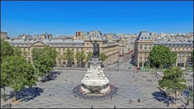 Que symbolise le lion couché au pied du monument de la République sis au centre de la place ?