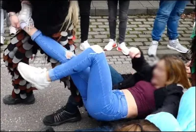 Pendant la pause méridienne, Caroline, une élève de 4e, est poursuivie dans la cour par deux de ses copines. Elle se réfugie près d'un mur et s'assoit au sol. Chacune de ses amies saisit une jambe et enlève ses chaussures. La scène se déroule devant toi. Quelle est ta réaction ?