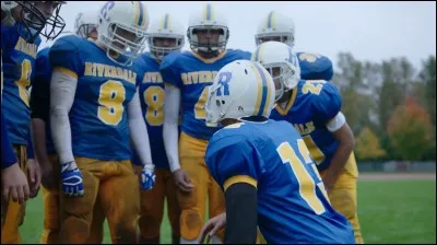 Quelle lettre apparaît sur les vestes bleues de l'équipe de foot ?