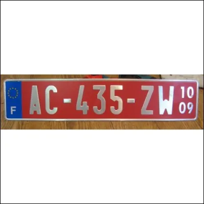 Qu'indique une plaque d'immatriculation sur fond rouge ?