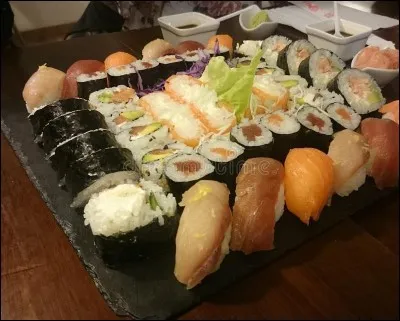 Il déguste des sushis __ Japon, __ délicieux !