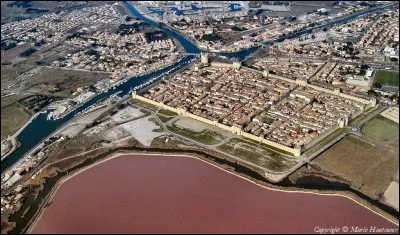 Aigues-Mortes est une commune française située dans la pointe sud du département du Gard. Que signifie 'Aigues' ?