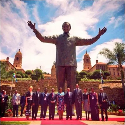 Cette oeuvre rend hommage &agrave; un homme unique (1918-2013), symbole de l'opposition &agrave; l'apartheid et premier pr&eacute;sident noir d'Afrique du Sud (1994-1999). Le voyez-vous, c'est &eacute;crit en dessous, c'est &eacute;crit noir sur blanc ?