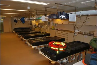 A l'étage numéro un, se trouve une douzaine de lits, séparés par des rideaux. Les blessés, malades se retrouvent ici et sont examinés avant de rejoindre le service correspondant à leur pathologie. Ce sont les...