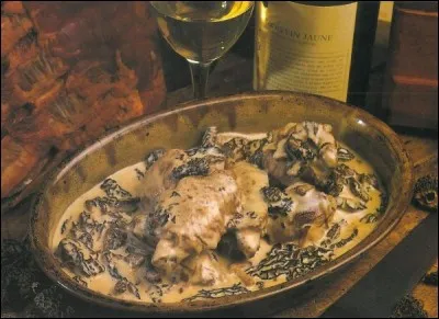 Avec quoi cuisine-t-on le coq dans un plat traditionnel du Jura ?