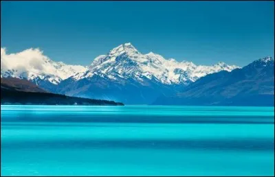 Ce que l'on voit à l'horizon, c'est l'impressionnant mont Cook, par eaux calmes, on peut en voir le reflet dans le lac. Remarquez sa teinte turquoise irréelle qui ressort magnifiquement au milieu de la vallée glaciaire. 
Il est encore plus beau que le lac Tekapo, lequel est-ce ?