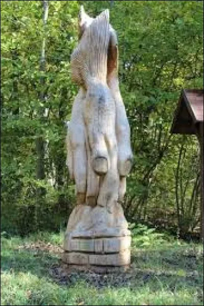 Dans quel petit village situé au nord-ouest des Vosges peut-on admirer aux abords des sentiers des sculptures créées lors d'un concours organisé chaque année non loin de là ?