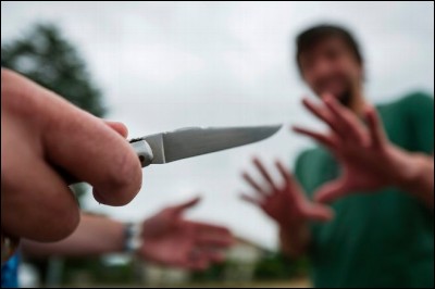 Une femme se fait agresser dans la rue par un homme armé d'un couteau.