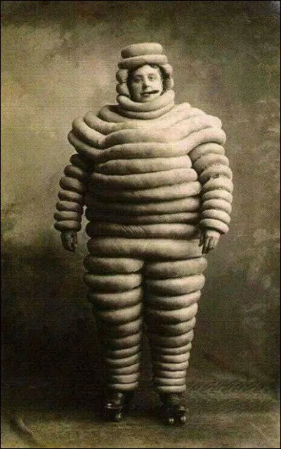En 1898, Édouard Michelin aurait dit à son frère, devant une pile de pneus, ''Avec des bras, on aurait un bonhomme''. On prit Bibendum dans un dessin refusé par une brasserie allemande, soit un buveur de corpulence. Ainsi était née la mascotte de la manufacture française. C'est devenu l'emblème de la marque. Nommez ce bonhomme debout, cigare à la bouche, avant qu'il ne s'enflamme :
