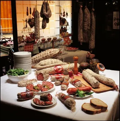 Quel est le nom de la tradition gastronomique lyonnaise qui consiste à servir de la cochonnaille ou des tripes le matin ?