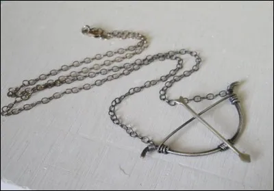 Ce bijou duplique une arme en pendentif qui appartient à une héroïne. Qui est l'auteur (et l'oeuvre) cachés derrière lui ?