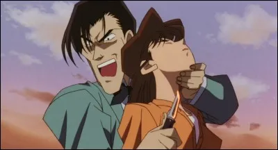 Dans le film 2 intitulé "La Quatorzième cible", qu'est-ce que Ran a tenu dans sa main et a serré contre elle tout en étant prise en otage par le meurtrier (objet en rapport avec Shinichi) ?