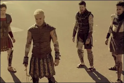 Dans le clip "Centuries" du groupe "Fall Out Boy", comment meurt le bourreau dans l'ar&egrave;ne contre le groupe des quatre prisonniers ?