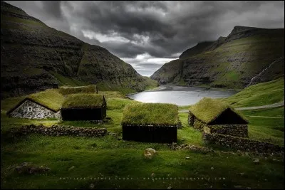 Saksun, le village que l'on voit ici, est situé dans le fond d'un fjord qui était autrefois un bras de mer, entouré de hautes montagnes. Le photographe parle de paysages Tolkien comme ces maisons typiques avec de l'herbe sur le toit. Ici, on ne sent pas le besoin de fermer sa maison à clé ou de cadenasser son vélo.
En parlant de vélo, dans quel pays est-on ?