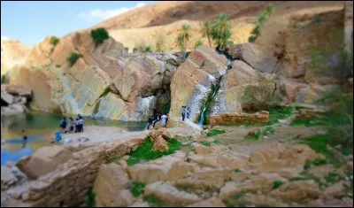 ''Porte d'entrée'' du Sahara, son nom signifie ''Cité du bonheur'', c'est l'oasis la plus proche d'Alger (241 km). La photo montre une série de petites cascades en amont de l'oued. La montagne Kerdada lui donne l'allure d'une forteresse : c'est une étape ancienne des caravanes et une halte pour nomades, une ville historique .
Comment appelle-t-on ce lieu qui dès 1930 était déjà très touristique ?