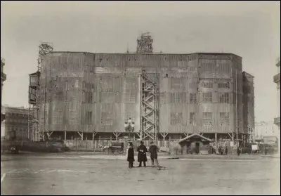 On ne les voit pas, de 1861 à 1875, dès la première pierre sur ce chantier au sous-sol de qualité médiocre, ils ont été là présents et soigneusement cachés derrière des échafaudages recouverts de planches et de verrières qui masquent la façade principale.
Qui sont ces ébénistes, ferronniers, marbriers, mosaïstes, parqueteurs, peintres et sculpteurs, staffeurs, stucateurs, absents sur la photo ?