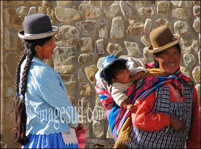 C'est un peuple de montagnes : on assiste ici à une scène de la vie quotidienne en habits traditionnels. Il s'agit d'une mère avec son bébé, dans l'écharpe de portage sur le dos et d'une jeune fille avec ses longues nattes liées par de la dentelle, la « tula ou tulma». Toutes les deux portent fièrement le chapeau melon ou bombin, les cholas (cholitas).
Quel est ce peuple de l'altiplano ?