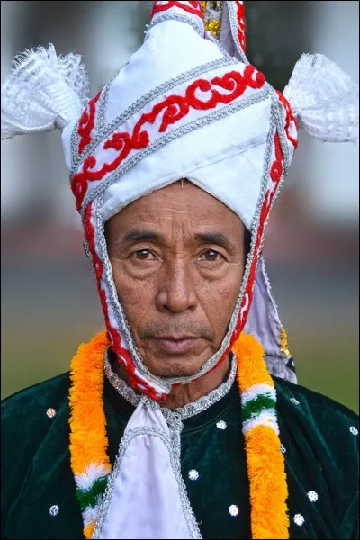 Ce danseur appartient à un groupe socio-culturel sino-tibétain majoritaire dans l'état du Manipur : on en retrouve aussi au Myanmar et au Bangladesh. Ils ont une histoire écrite documentée depuis 1445 av. Leurs pratiques religieuses rendent hommage aux divinités traditionnelles et aux ancêtres.
À quel groupe appartient cet ancien s'apprêtant à danser une danse rituelle en honneur des dieux ?