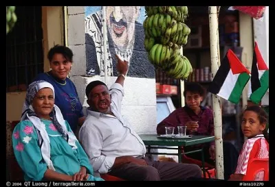 Ces gens habitent un havre de paix en plein désert, dans la vallée du Jourdain en Palestine. La ville a une forte renommée pour ses sites d'histoire incomparables et aussi ses sols fertiles dont l'on voit les fruits, à côté de cette famille.
D'où viennent ces Palestiniens dont le chef de famille nous pointe une murale de Yasser Arafat ?