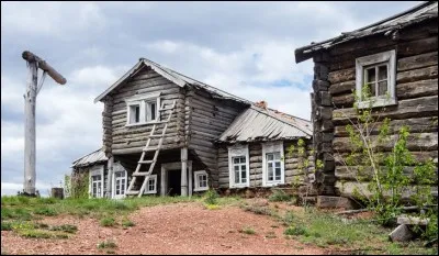 Voici ce qui représente le type de logements le plus traditionnel des zones rurales de ce grand pays. C'est un assemblage fait de troncs non équarris, généralement encore couverts de leur écorce. 
Localisez le pays où ces maisons étaient construites à la main avec des outils de sorte que le bois s'emboîtât sans clou. On remplissait les espaces vides entre les billes avec de l'argile.