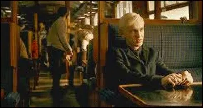 Lors du voyage en Hogwarts Express, Harry décide de se cacher pour épier la conversation de Draco Malfoy. Comment fait-il pour ne pas être vu ?
