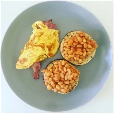 Les "backed beans" sont un incontournable du petit-déjeuner anglo-étasunien, mais ces derniers y rajoute un ingrédient : lequel ?