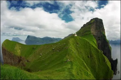 Un ferry désert Trøllanes dans les îles Féroés. C'est ensuite une succession de montagnes qu'on franchit par des tunnels jusqu'au petit phare qui veille depuis l'île de Kalsoy, cette île légendaire où les phoques étaient auparavant, des humains. La vue du phare, avec la grande falaise, est impressionnante.
À quel pays appartiennent ces îles ?