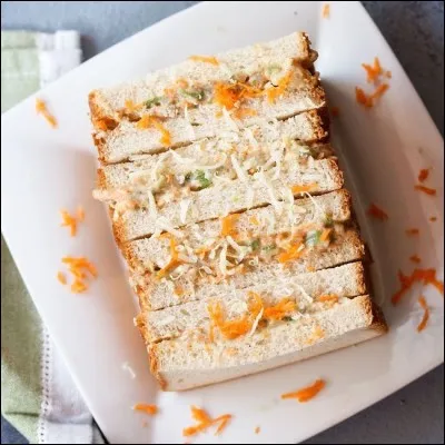 Complétez la phrase avec le verbe au présent de l'indicatif : "Elle ... un sandwich à la mayonnaise".