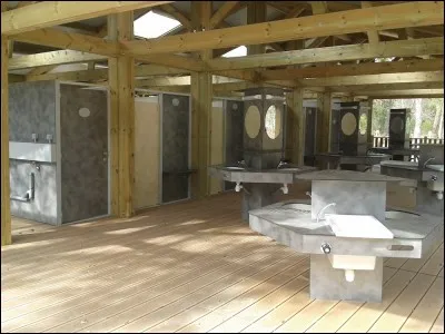 Les personnes ayant choisi les places de tentes peuvent prendre leur douche et faire leurs besoins dans ce lieu. C'est le bloc...