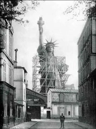 Photo de la rue Chazelles où fut construite la statue de la Liberté dans les ateliers de Bartholdi : on voit se profiler cette statue de la Liberté qui éclaire le monde, celle qui aujourd'hui domine le port de New York. Sa tête sera exposée à l'Expo de 1878 : il vous faut trouver l'année de la photo :