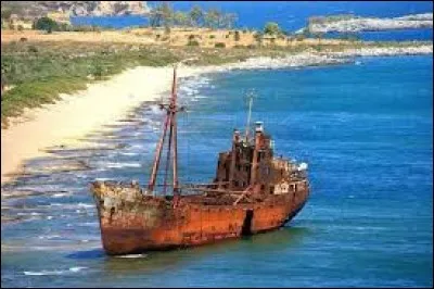 Nous voyons un navire grec célèbre pour son emplacement pittoresque sur une belle plage de sable accessible : construit au Danemark en 1950, il s' est échoué en 1981. On dit, de ce petit cargo, qu'il faisait de la contrebande entre la Turquie et l'Italie et qu'il s'est retrouvé là bien volontairement.
Nommez ce site de carte postale et trouvez le nom de ce tas de tôles qui y rouille :