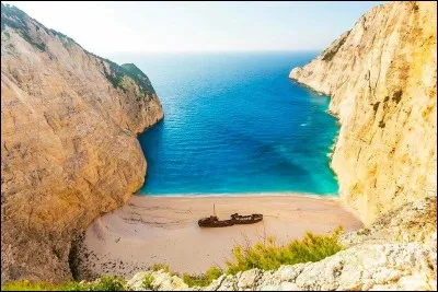 Il s'agit d'une des plages les plus célèbres de Grèce, pour son rivage et son eau claire. On trouve cette épave sur la rive nord-ouest de Zakynthos : c'est depuis octobre 1980 que le navire y a élu domicile, il est presque devenu une attraction touristique.
Pouvez-vous situer cet endroit de rêve et nommer le bateau qui y repose ?