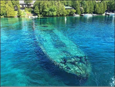 On voit une épave au beau milieu du havre. Il s'agit d'une goélette à deux mâts construite en 1867 et dont la coque gît sous à peine 2 m d'eau claire, un spécimen rare des ''great lakes Schooners'' embarcations configurées en arc et en poupe, peu profondes à fond plat et à nervures dures (cales carrées). Plusieurs croisières passent à coté : quel est ce navire et où est-on ?