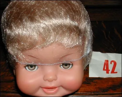 Que représente l'étiquette à côté de la tête de la poupée Bella?