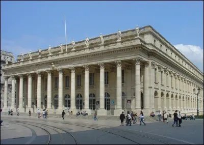 Choisissez l'option appropriée : "She can't answer the phone because she is  the theatre." ?