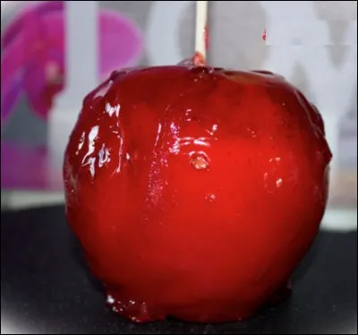 Quel est le nom de cette friandise, composée d'une pomme fraîche entourée de sucre caramélisé et colorée en rouge ?