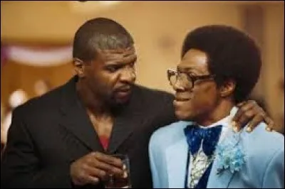 Qui est ce monsieur, à côté du monsieur avec sa coupe afro et portant des lunettes ?