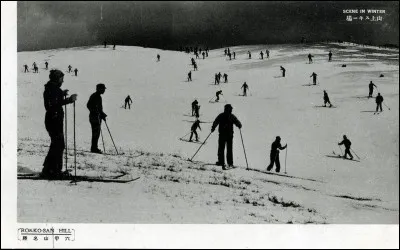 La photo a été prise vers 1940. De cette montagne, on a une vue panoramique sur la baie d'Osaka ou une magnifique vue de nuit sur la ville de Kobe. 
Est-ce la qualité de la neige, la chaleur du temps ou la technique des skieurs, mais peu glissent vraiment ? Sont-ce des fondeurs ? Mais surtout, où skient-ils ?