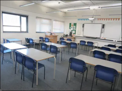 Cette pièce aux allures d'une salle de classe sert de formation ou de réunion. Combien voyez-vous de tableau(x) ?