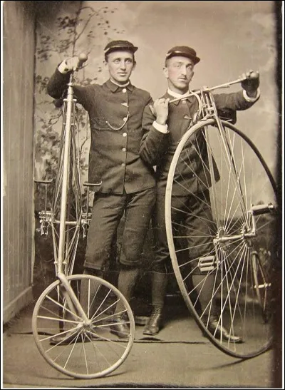 Cette photo date des années 1880 : on dit que ces livreurs sont équipés de vélo à grande roue. Il y en a un qui pose à côté d'un modèle ordinaire et son copain est équipé d'un vélo de sécurité. Ce sont des livreurs, des facteurs, des genres de postiers.
Quel est le nom anglais de leur travail ?