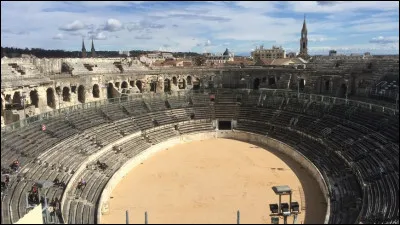 Dans quelle ville du Gard fut construit en 90 ap. J.-C. un amphithéâtre romain pouvant accueillir aujourd'hui 25 000 spectateurs ?