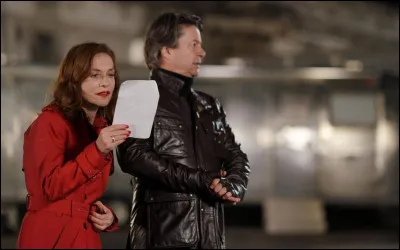 Quel stratagème élaborent les agents pour justifier la présence d'Isabelle Huppert sur deux tournages différents la même nuit ?