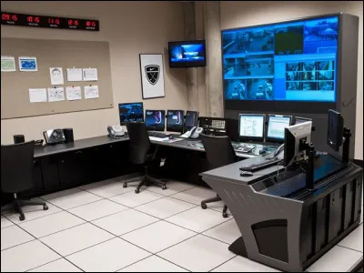 Dans ce lieu, un agent de sécurité est toujours présent pour veiller sur les passagers et membres d'équipage grâce aux caméras de surveillance. Il y a un portrait robot dans la salle, où se trouve-t-il ?