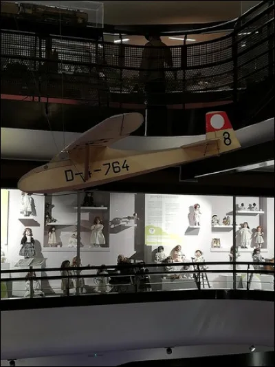 Pour poursuivre ta route au musée du Jouet, il te faut un moyen de locomotion. Voici un avion prêt à t'emmener pour la suite du périple. Pour monter, il te faut additionner les 3 chiffres inscrits à droite de l'aile. Quel est le bon résultat ?