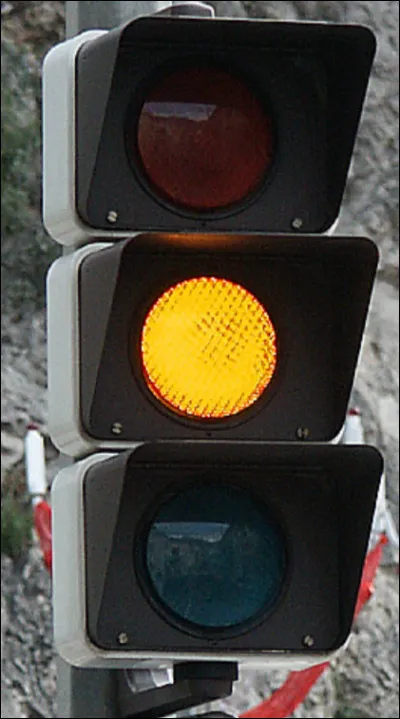 Sur la route, vous arrivez près du feu tricolore et il passe à l'orange. Que faites-vous ?