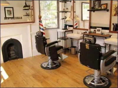 Pour terminer la partie générale de la prison, voici un endroit où hommes et femmes doivent passer pour avoir barbes et cheveux réglementaires. C'est un salon de coiffure mixte. Combien de personnes peuvent prendre place sur les sièges ?